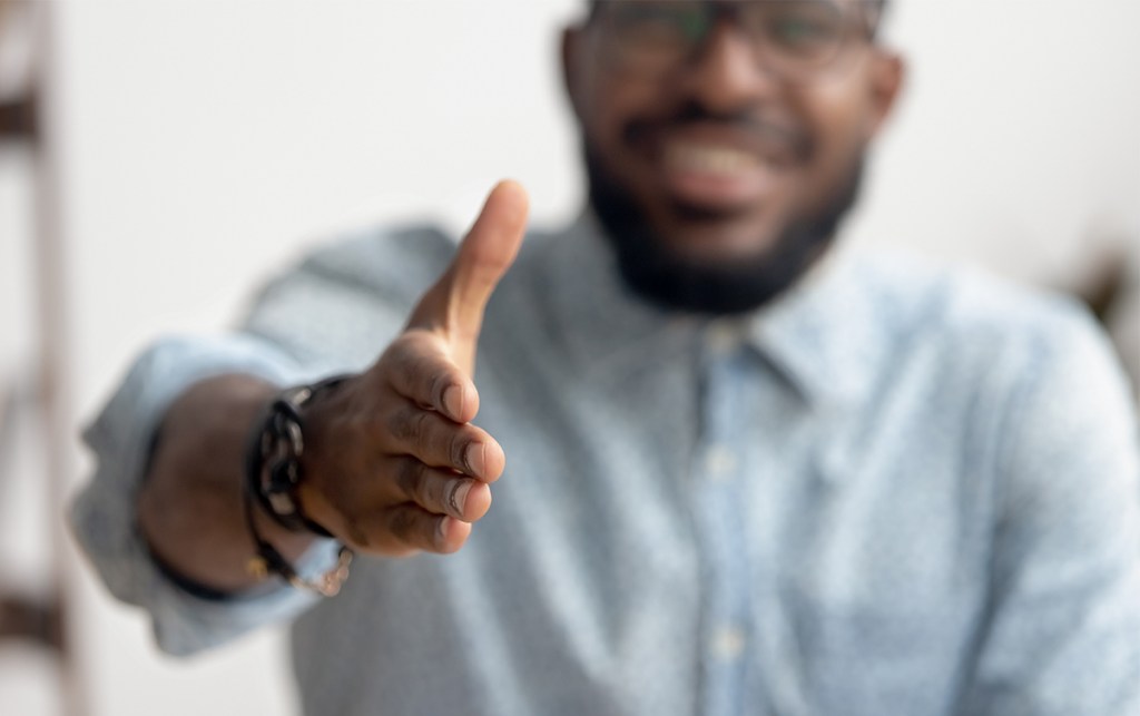 An African-American businessman reaches out for a handshake