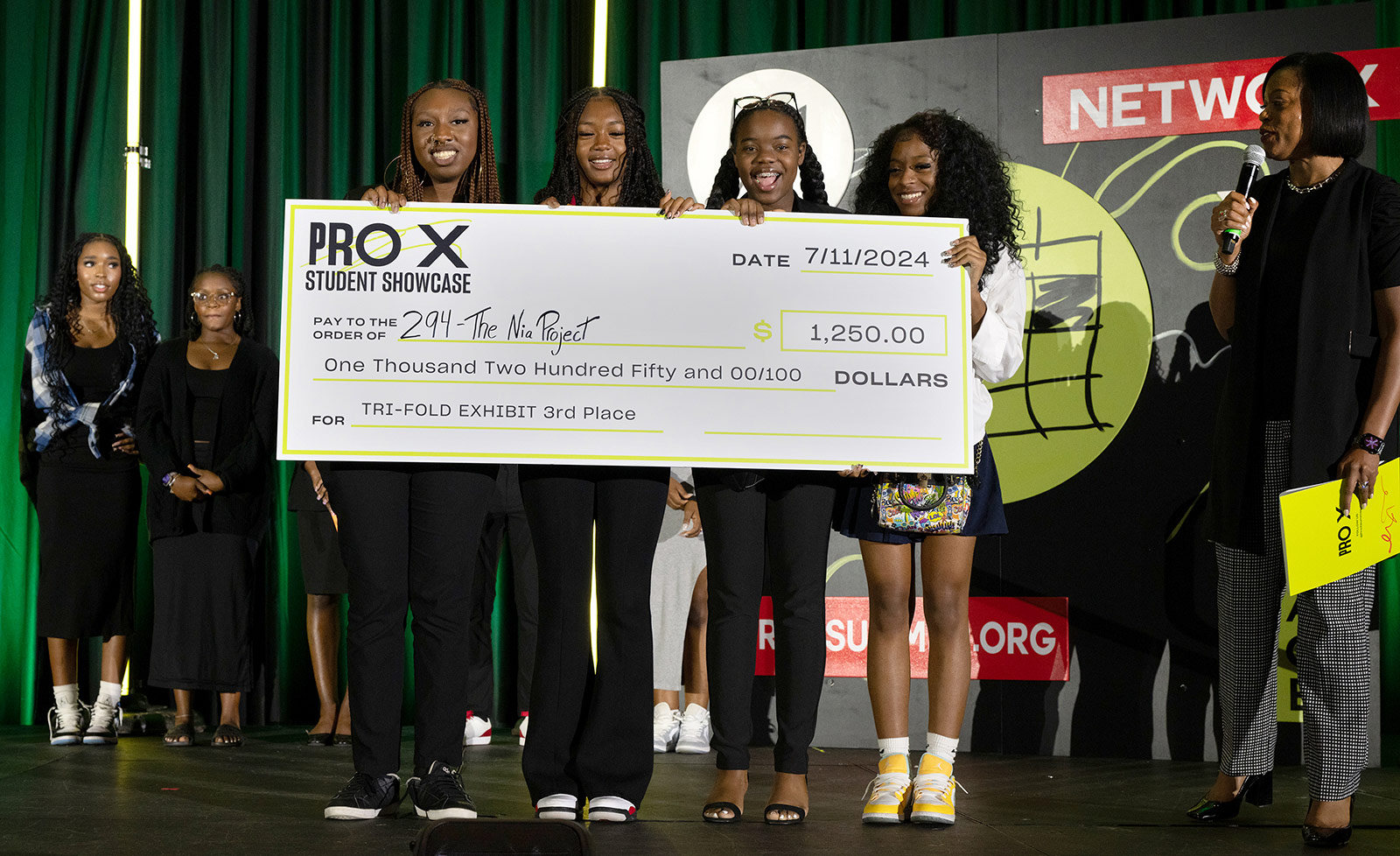 ProX summer interns hold a life-sized check at the ProX showcase