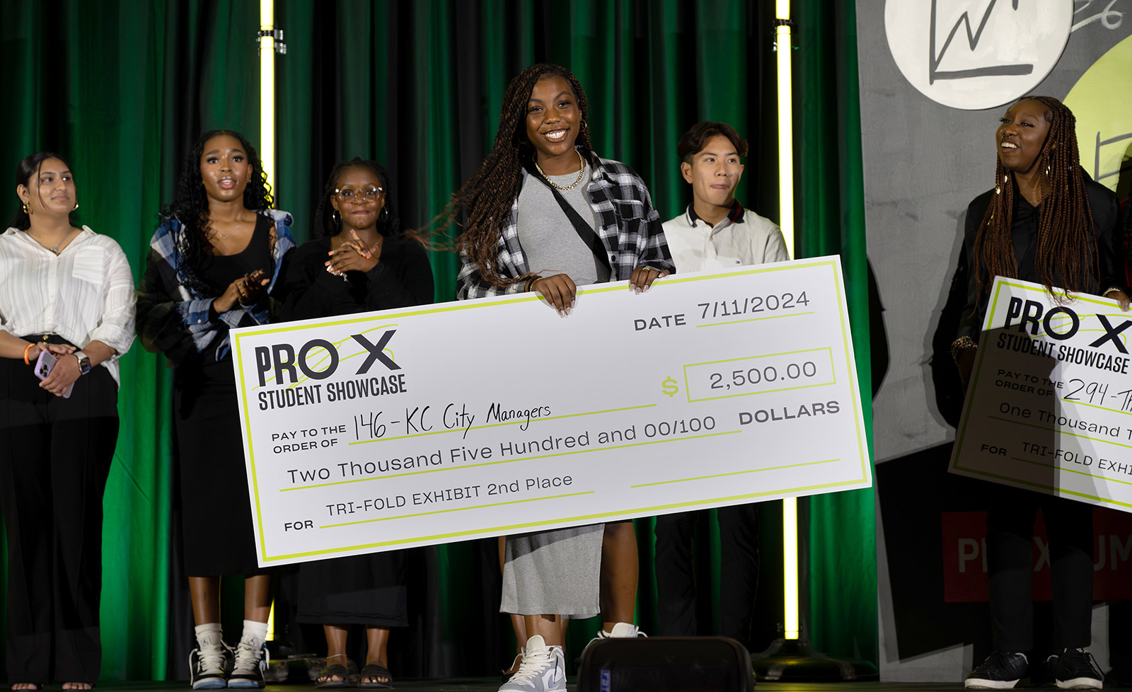 ProX summer interns hold a life-sized check at the ProX showcase