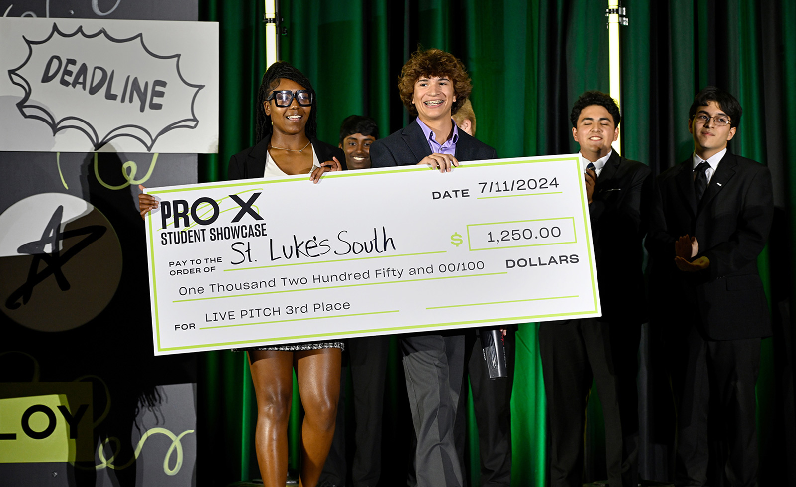 ProX summer interns hold a life-sized check at the ProX showcase