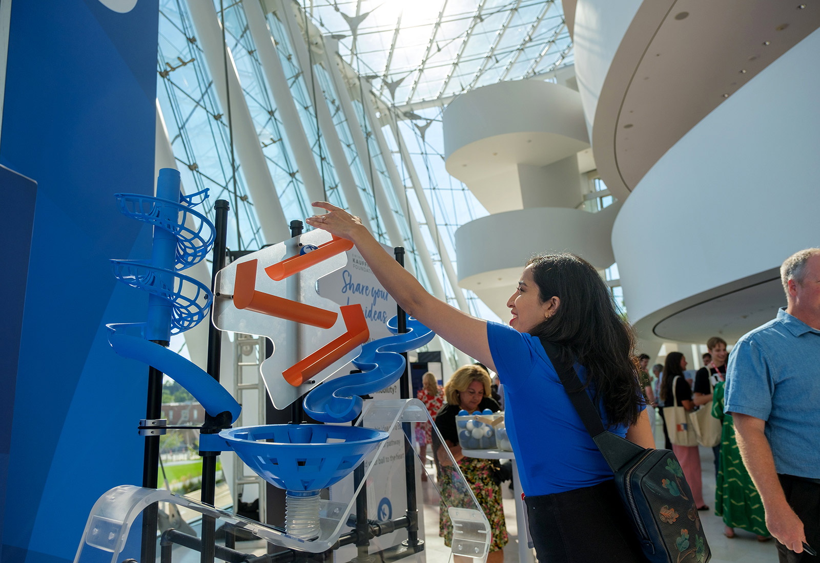 A TEDxKC attendee participates in the Kauffman Foundation acrylic heart installation at the Kauffman Center for Performing Arts