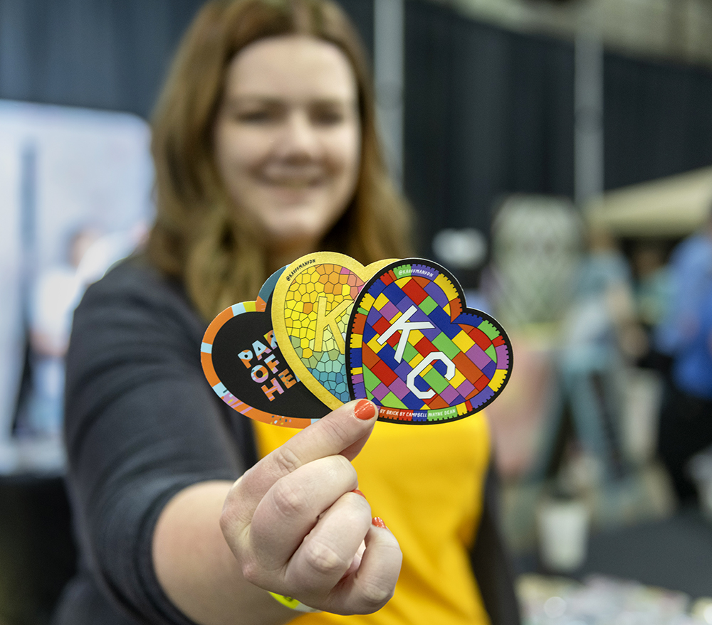 A person holds three stickers representing three of the hearts on display during the Parade of Hearts at Bartle Hall