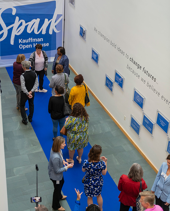 Community members walk the blue carpet at the Ewing Marion Kauffman Foundation Spark Open House event