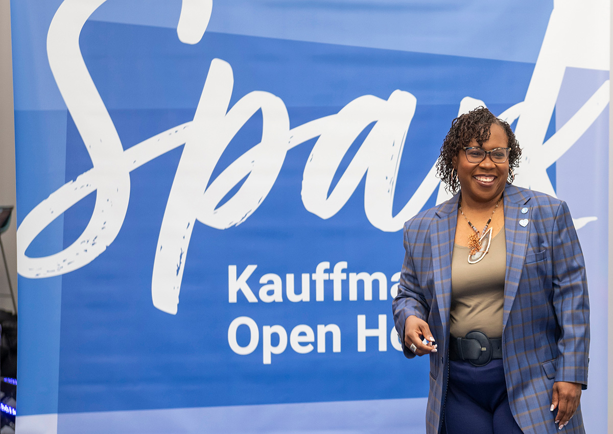 Dr. DeAngela Burns-Wallace stands in front of the Spark Kauffman Open House banner