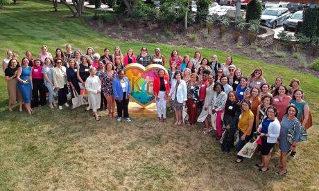 Kauffman associates pose for a photo with United WE staff next to the KC heart located at the Kauffman Foundation.